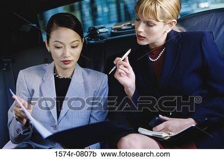 Two businesswomen sitting in a car View Large Photo Image Stock Image - Two businesswomen sitting in a car. Fotosearch
