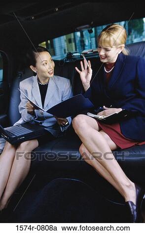 Two businesswomen sitting in a car View Large Photo Image Stock Image - Two businesswomen sitting in a car. Fotosearch
