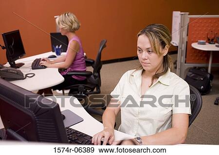 Two businesswomen sitting in an office View Large Photo Image Stock Photo - Two businesswomen sitting in an office. Fotosearch
