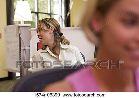 Two businesswomen sitting in an office View Large Photo Image Stock Photo - Two businesswomen sitting in an office. Fotosearch