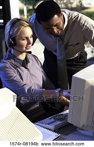 Stock Image - Two customer service representatives discussing. Fotosearch