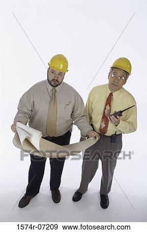 Stock Photo - Two foremen holding walkie-talkies and blueprints. Fotosearch
