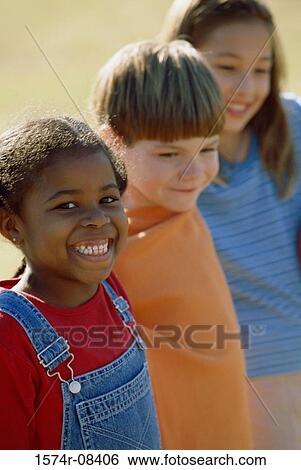Two girls and a boy standing together View Large Photo Image Stock Photograph - Two girls and a boy standing together. Fotosearch