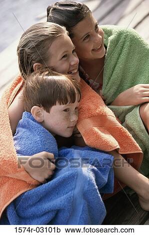 Two girls and a boy wrapped in towels sitting on a dock View Large Photo Image Stock Image - Two girls and a boy wrapped in towels sitting on a dock. Fotosearch