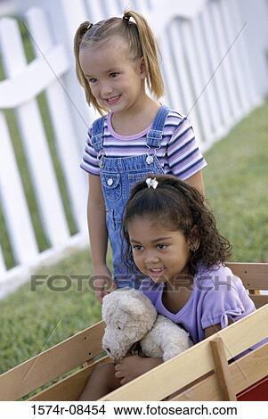 Two girls playing with a push cart View Large Photo Image Picture - Two girls playing with a push cart. Fotosearch