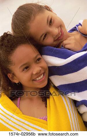 Two girls wrapped in towels on the beach View Large Photo Image Stock Image - Two girls wrapped in towels on the beach. Fotosearch
