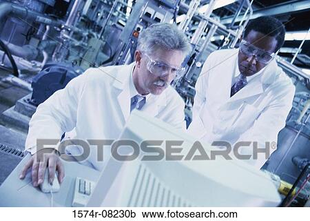 Stock Image - Two male researchers working on a computer. Fotosearch