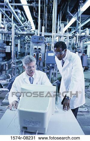 Two male researchers working on a computer View Large Photo Image Stock Image - Two male researchers working on a computer. Fotosearch