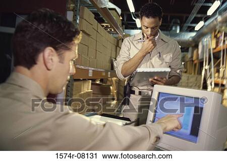 Two men working on inventory View Large Photo Image Stock Image - Two men working on inventory. Fotosearch