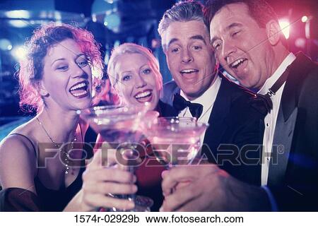 Stock Image - Two mid adult couples toasting at a party. Fotosearch