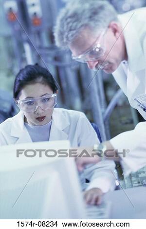 Two researchers working on a computer View Large Photo Image Picture - Two researchers working on a computer. Fotosearch