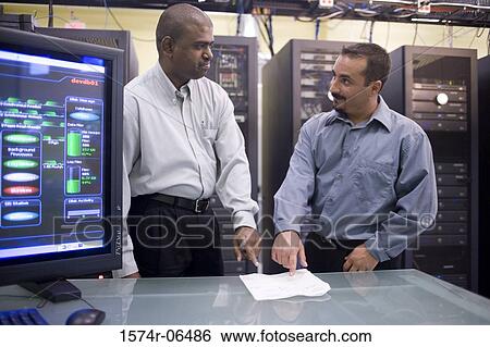 Two technicians standing in front of a network servers View Large Photo Image Stock Photograph - Two technicians standing in front of a network servers. Fotosearch