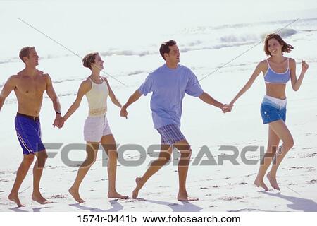Two young couples holding hands together at the beach View Large Photo Image Stock Image - Two young couples holding hands together at the beach. Fotosearch