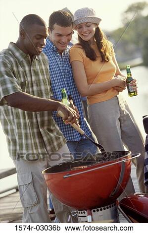 Two young men and a young woman at a barbecue View Large Photo Image Stock Image - Two young men and a young woman at a barbecue. Fotosearch