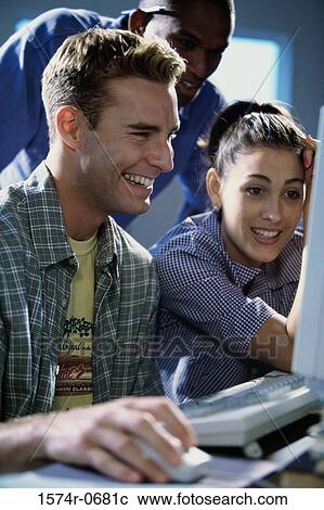 Two young men and a young woman using a computer View Large Photo Image Stock Image - Two young men and a young woman using a computer. Fotosearch