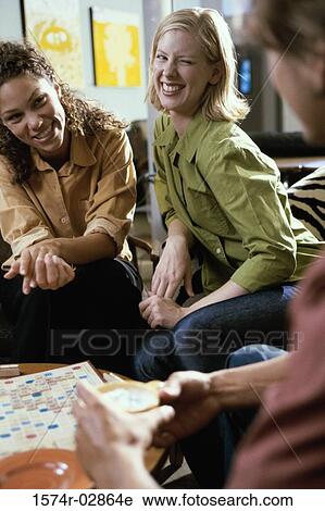 Two young women and a young man playing scrabble View Large Photo Image Stock Image - Two young women and a young man playing scrabble. Fotosearch