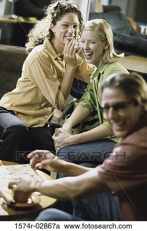 Two young women and a young man sitting in a cafeteria View Large Photo Image Stock Image - Two young women and a young man sitting in a cafeteria. Fotosearch