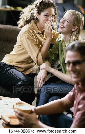 Two young women and a young man sitting in a cafeteria View Large Photo Image Stock Image - Two young women and a young man sitting in a cafeteria. Fotosearch