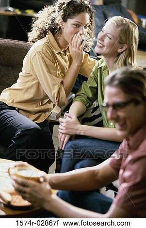 Two young women and a young man sitting in a cafeteria View Large Photo Image Stock Image - Two young women and a young man sitting in a cafeteria. Fotosearch