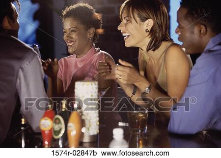 Two young women and two young men sitting in a bar View Large Photo Image Stock Image - Two young women and two young men sitting in a bar. Fotosearch