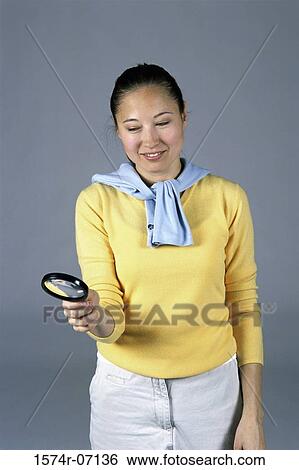 Woman holding a magnifying glass View Large Photo Image Stock Photograph - Woman holding a magnifying glass. Fotosearch