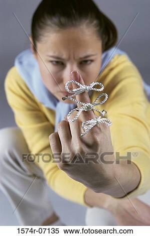 Woman sitting with string tied around her index finger View Large Photo Image Stock Photography - Woman sitting with string tied around her index finger. Fotosearch