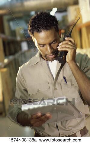 Stock Image - Worker talking on a walkie-talkie. Fotosearch