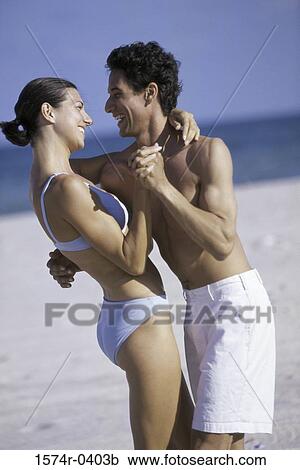 Stock Image - Young couple dancing on the beach. Fotosearch