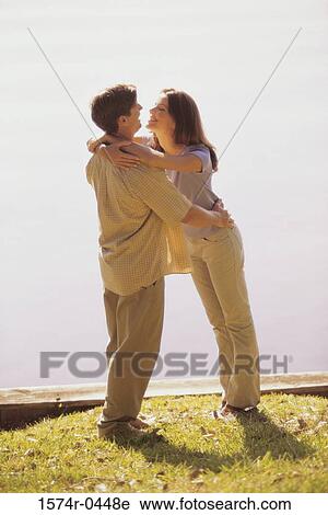 Young couple holding each other View Large Photo Image Stock Image - Young couple holding each other. Fotosearch