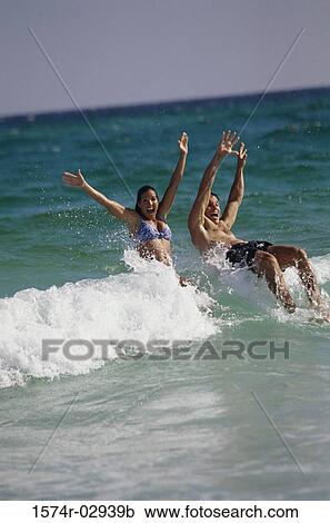 Stock Image - Young couple playing on the beach. Fotosearch