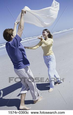 Young couple playing on the beach View Large Photo Image Stock Image - Young couple playing on the beach. Fotosearch
