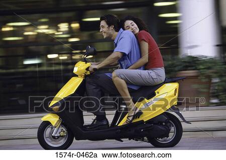 Young couple riding on a motor scooter View Large Photo Image Stock Image - Young couple riding on a motor scooter. Fotosearch