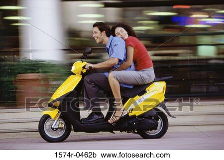 Young couple riding on a motor scooter View Large Photo Image Stock Image - Young couple riding on a motor scooter. Fotosearch