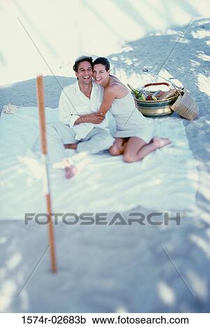 Young couple sitting on the beach View Large Photo Image Stock Image - Young couple sitting on the beach. Fotosearch