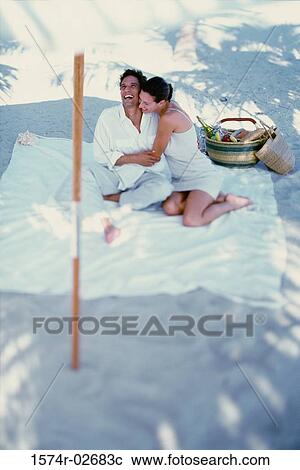 Young couple sitting on the beach View Large Photo Image Stock Image - Young couple sitting on the beach. Fotosearch