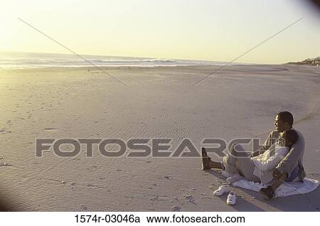 Young couple sitting on the beach View Large Photo Image Stock Image - Young couple sitting on the beach. Fotosearch