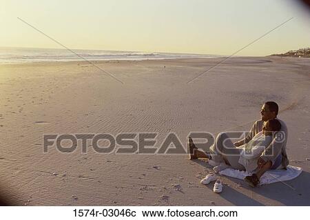 Young couple sitting on the beach View Large Photo Image Stock Image - Young couple sitting on the beach. Fotosearch