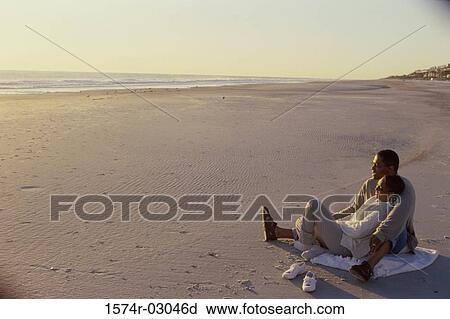 Young couple sitting on the beach View Large Photo Image Stock Image - Young couple sitting on the beach. Fotosearch