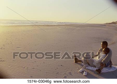 Young couple sitting on the beach View Large Photo Image Stock Image - Young couple sitting on the beach. Fotosearch