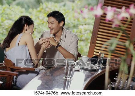 Young couple sitting together at a counter View Large Photo Image Stock Image - Young couple sitting together at a counter. Fotosearch