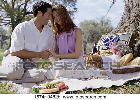 Stock Image - Young couple sitting together at a picnic. Fotosearch