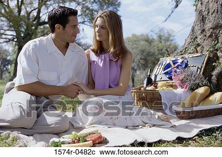 Young couple sitting together at a picnic View Large Photo Image Stock Image - Young couple sitting together at a picnic. Fotosearch