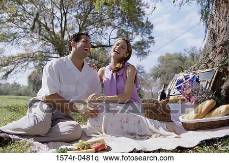 Young couple sitting together at a picnic View Large Photo Image Stock Photography - Young couple sitting together at a picnic. Fotosearch