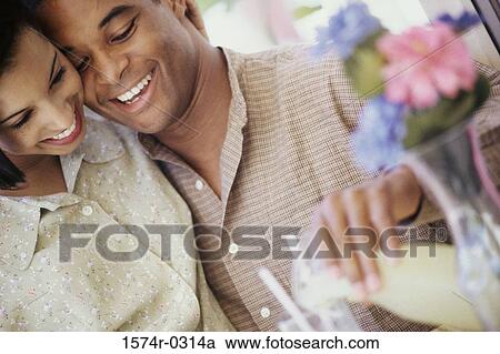 Young couple sitting together at a table View Large Photo Image Stock Image - Young couple sitting together at a table. Fotosearch