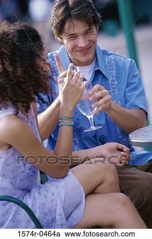 Young couple sitting together in a restaurant View Large Photo Image Stock Image - Young couple sitting together in a restaurant. Fotosearch
