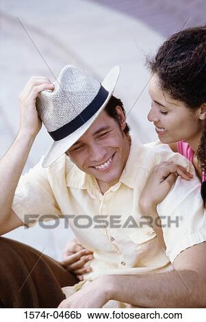 Young couple sitting together smiling View Large Photo Image Stock Image - Young couple sitting together smiling. Fotosearch