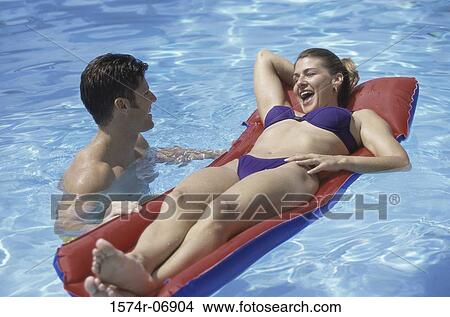 Young couple together in a swimming pool View Large Photo Image Picture - Young couple together in a swimming pool. Fotosearch