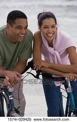 Stock Image - Young couple with bicycles on the beach. Fotosearch