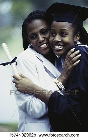 Young female graduate hugging her mother View Large Photo Image Stock Image - Young female graduate hugging her mother. Fotosearch