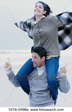 Young man carrying a young woman on his shoulders View Large Photo Image Stock Image - Young man carrying a young woman on his shoulders. Fotosearch